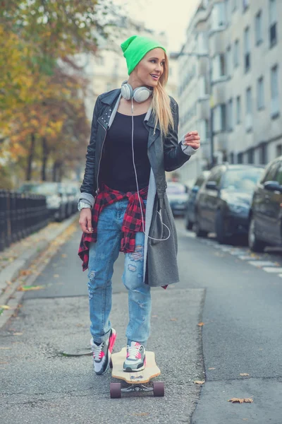 Cute young urban woman using a skate board — Stock Photo, Image