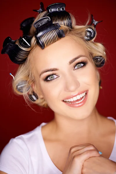 Cute blond woman with her hair in curlers — Stock Photo, Image