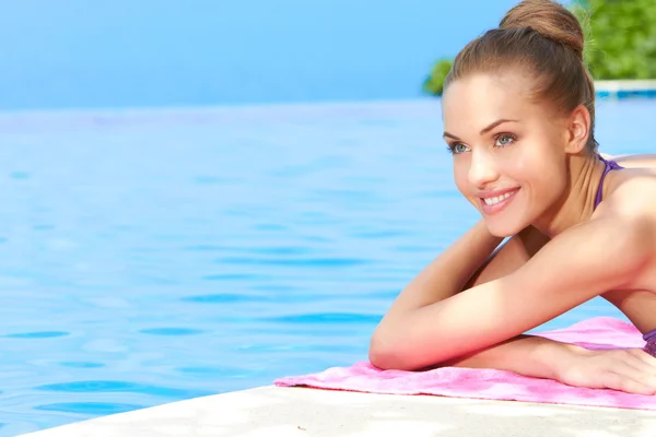 Bella giovane donna posa incline a bordo piscina — Foto Stock