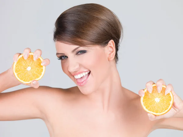 Vivacious playful woman with fresh orange slices — Stock Photo, Image