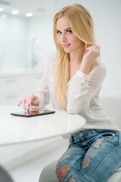 Femme blonde à la table avec tablette — Photo