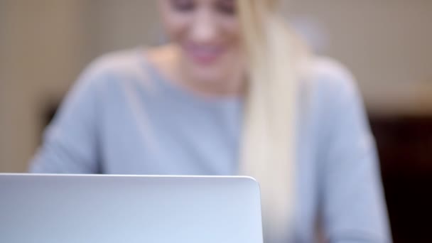 Lachende jonge vrouw die werkt op een laptop — Stockvideo