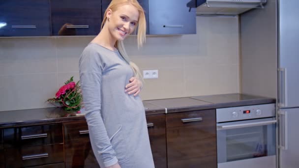 Glad gravid kvinna stående i köket — Stockvideo