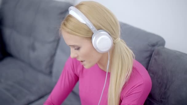 Mujer escuchando música desde el teléfono usando auriculares — Vídeo de stock