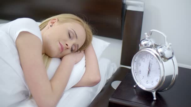 横になっている女性の目覚まし時計をオフにします。 — ストック動画