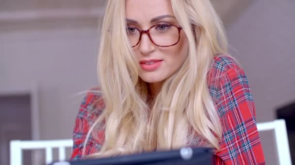 Blondine mit Brille beschäftigt mit Tablet — Stockvideo