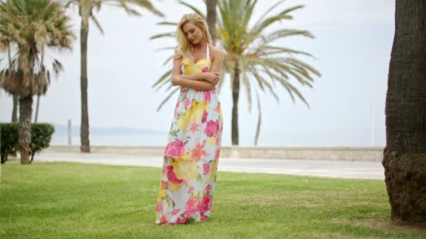 Blond kvinna bär långa Sun klänning promenader i parken — Stockvideo