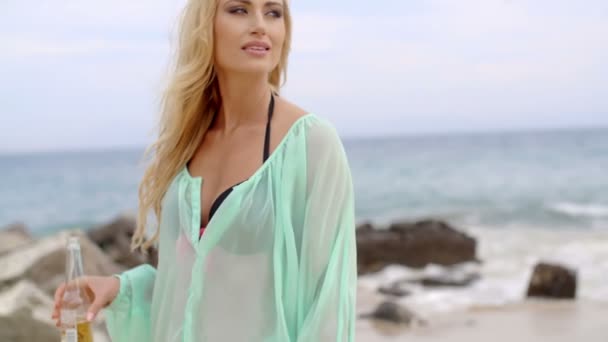 Blond kobieta trzymając butelkę piwa na plaży — Wideo stockowe