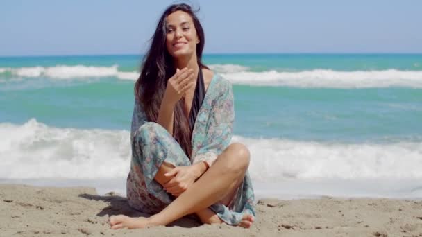 Menina bonita sentada na areia da praia — Vídeo de Stock