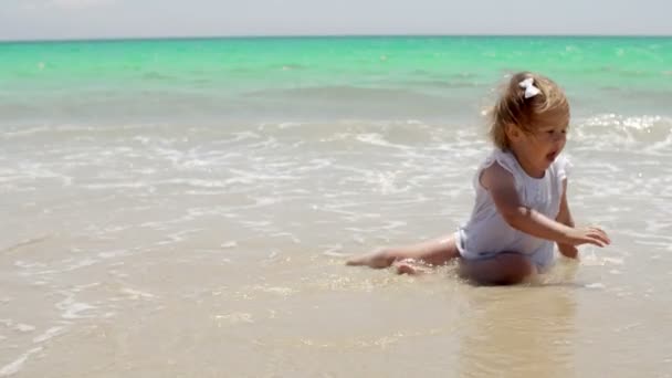 Kleines Mädchen sitzt an einem Strand — Stockvideo