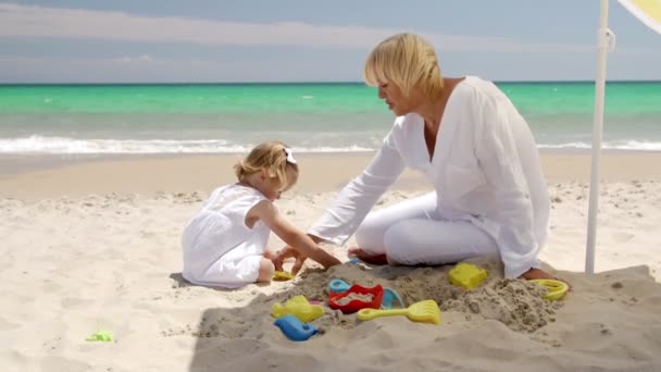 Niña y abuela jugando en la playa — Vídeo de stock