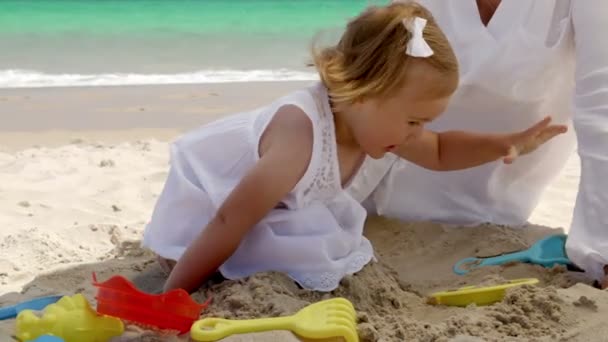 Niedliches junges Mädchen spielt im Sand — Stockvideo