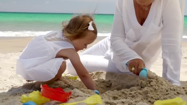 Klein meisje graven in strand zand — Stockvideo