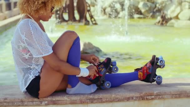 彼女のローラースケートを置く女の子 — ストック動画