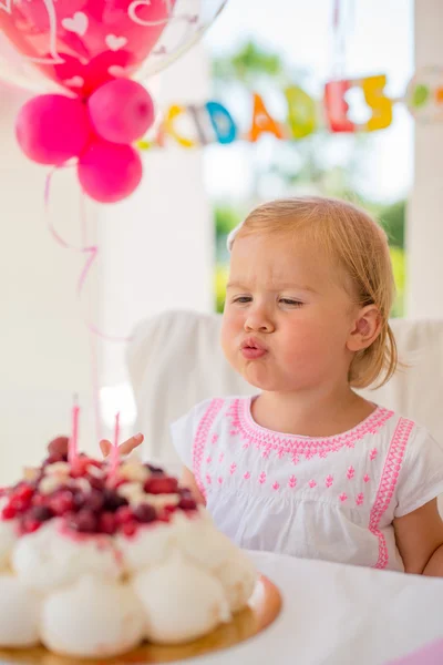 Lány fúj gyertyákat születésnapi torta — Stock Fotó