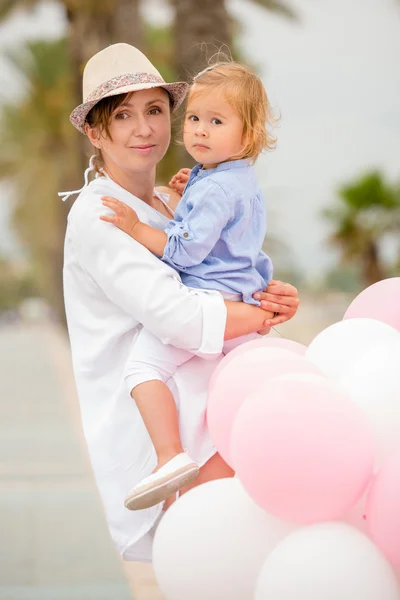 Trendy young mother holding her young daughter — Stok fotoğraf