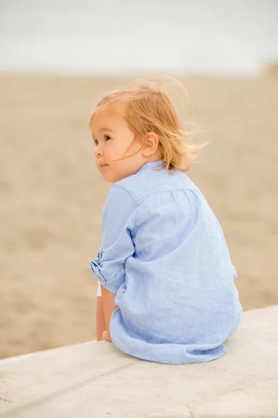 Pretty blond girl sitting overlooking the sea — Stockfoto