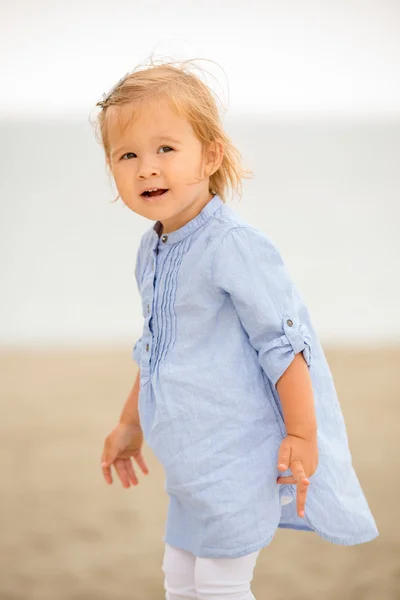 Little blond girl playing on the beach — Stockfoto