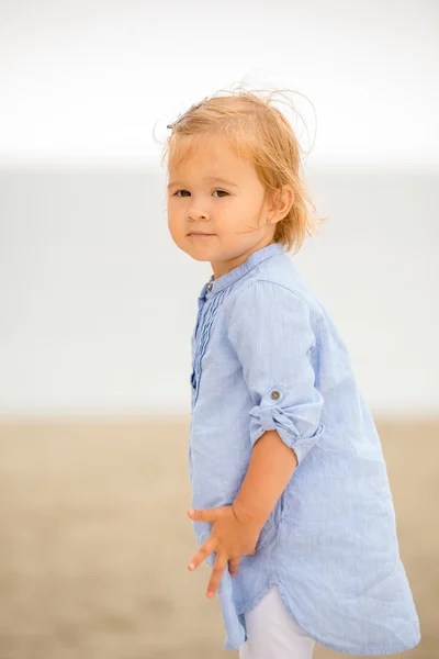 Little blond girl playing on the beach — Stockfoto