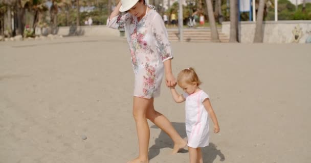 Madre con su hija caminando en la playa — Vídeo de stock