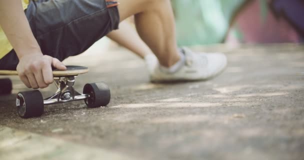 Muž sedící na skateboardu — Stock video