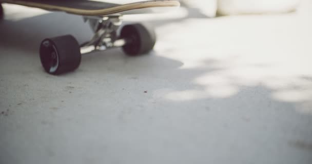 Ragazzo seduto su uno skateboard all'aperto — Video Stock