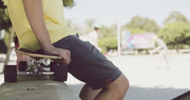 Bir duvara dengeli bir kaykay üzerinde oturan adam — Stok video