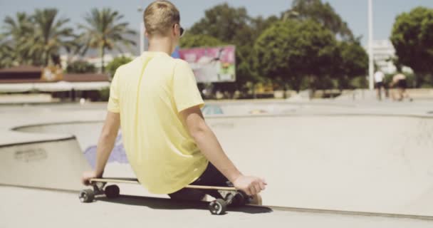 Έφηβος κάθεται στο του Longboard — Αρχείο Βίντεο