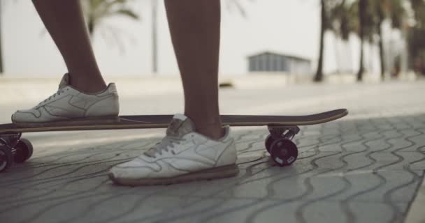 Pied d'un patineur sur longboard tout en prenant un repos — Video
