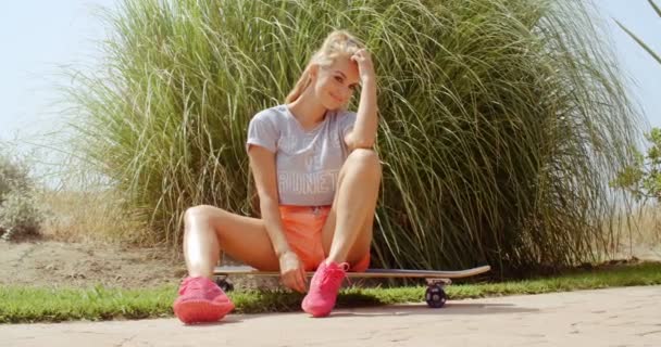 Esportivo bonita menina mulher sentada em seu skate — Vídeo de Stock