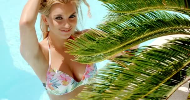 Mulher bonita na piscina segurando folhas de palma — Vídeo de Stock