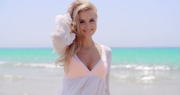 Красива жінка на пляжі посміхаючись на камеру — стокове відео