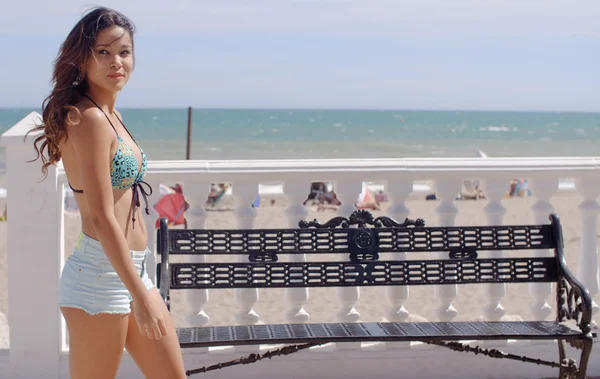 Sexy young woman strolling along a promenade — Stockfoto