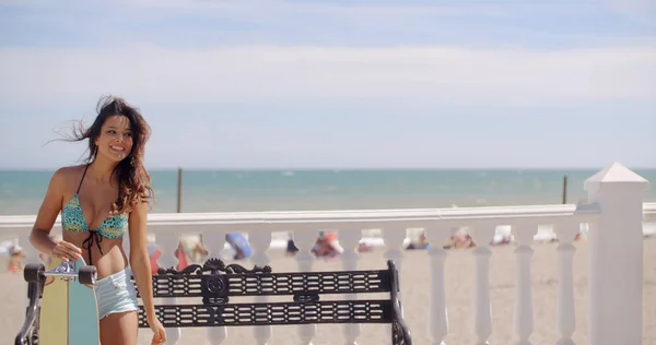 Jeune femme penchée sur son skateboard — Photo