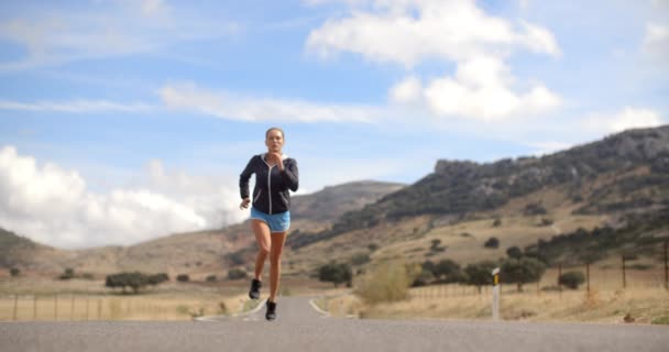 Fitress ragazza che corre sulla strada in montagna — Video Stock