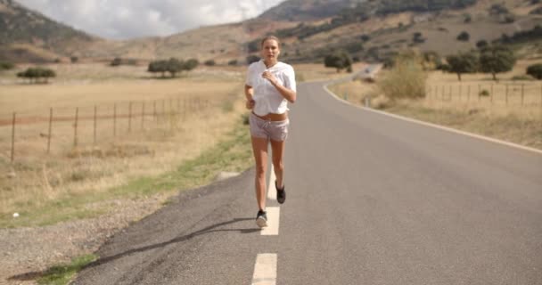 Fit meisje waarop bergweg — Stockvideo