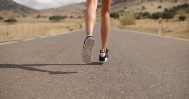 Подходящая девочка, бегущая по горной дороге — стоковое видео