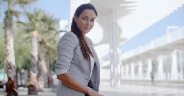 Elegant kvinna sitter på en bänk på en strandpromenad — Stockvideo