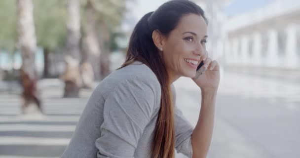 Mujer joven y relajada hablando en su móvil — Vídeo de stock