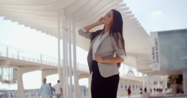 Stylische Frau mit langen Haaren, die auf einem Handy steht — Stockvideo