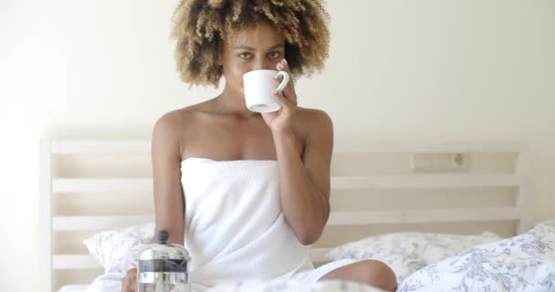 Mujer con taza de café en la cama — Vídeos de Stock