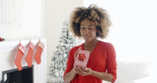 Woman shaking Christmas gift — Stockvideo