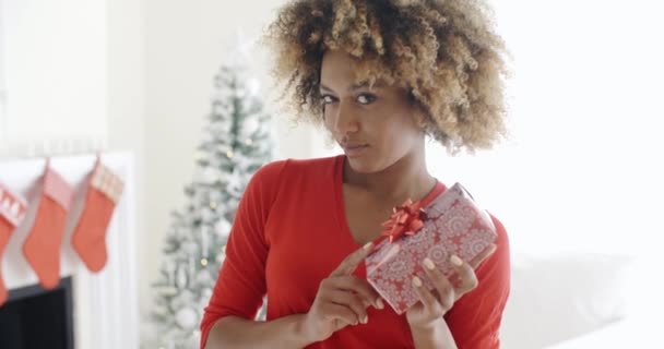 Mujer sacudiendo regalo de Navidad — Vídeos de Stock