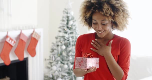 Woman shaking Christmas gift — Stockvideo