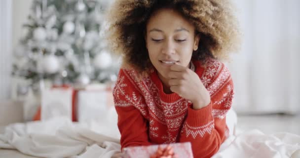 Zamyšlená mladá žena s vánočním dárkem — Stock video
