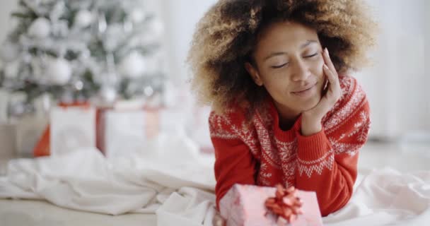 Mujer joven reflexiva con un regalo de Navidad — Vídeo de stock