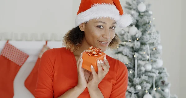 Donna in cappello di Babbo Natale in possesso di regalo — Foto Stock