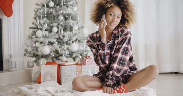 Mujer relajándose frente al árbol de Navidad — Foto de Stock