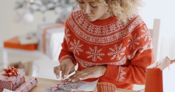 Woman carefully wrapping Christmas gift — Zdjęcie stockowe