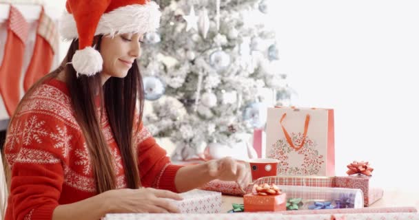 Frau sitzt beim Verpacken von Weihnachtsgeschenken — Stockvideo